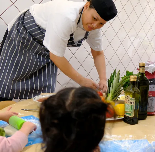 nursery cook asisting children with food